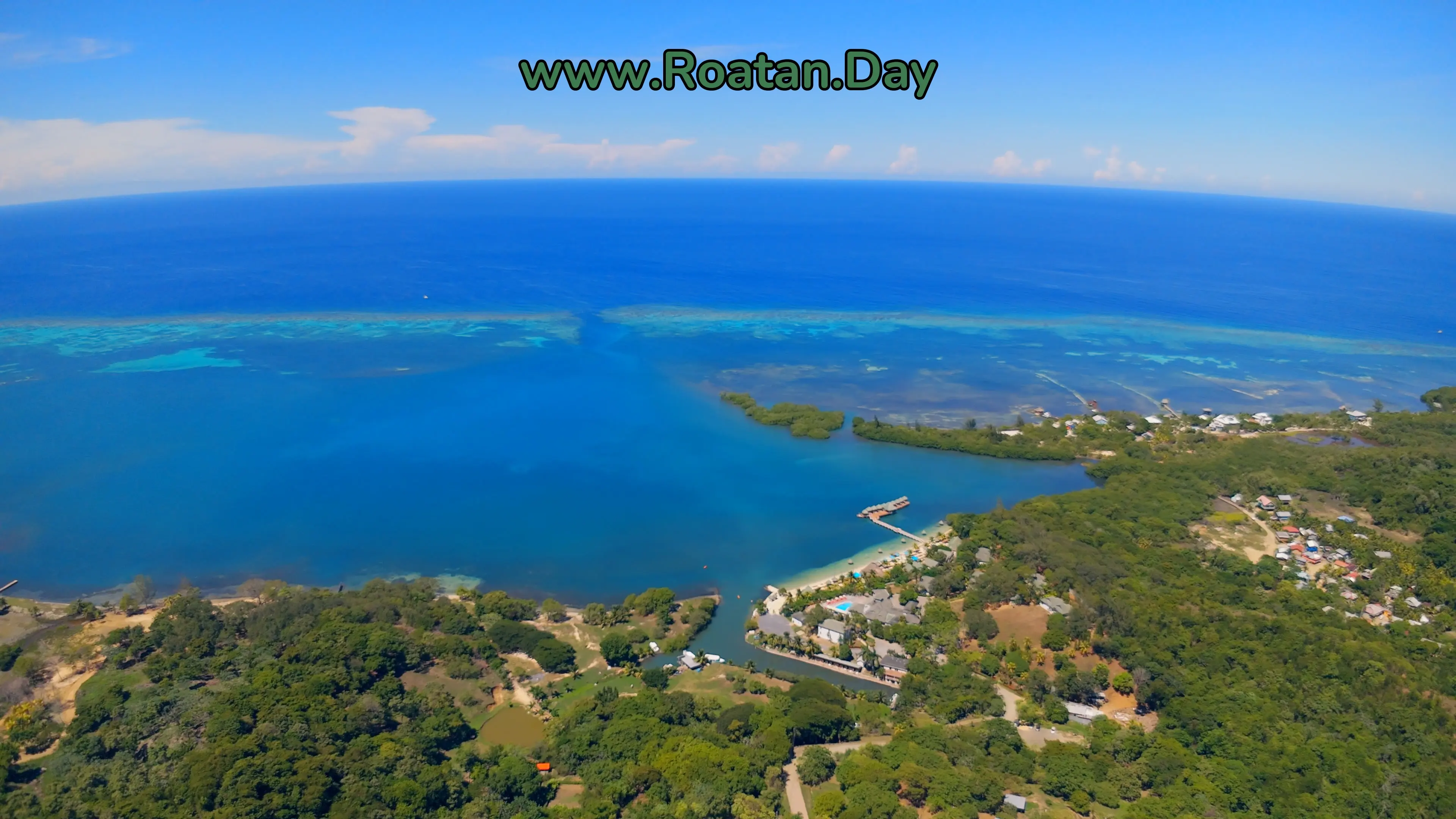 Turquoise Bay, Roatán, vue large du drone : la mer, la barrière de corail et l'entrée de la baie