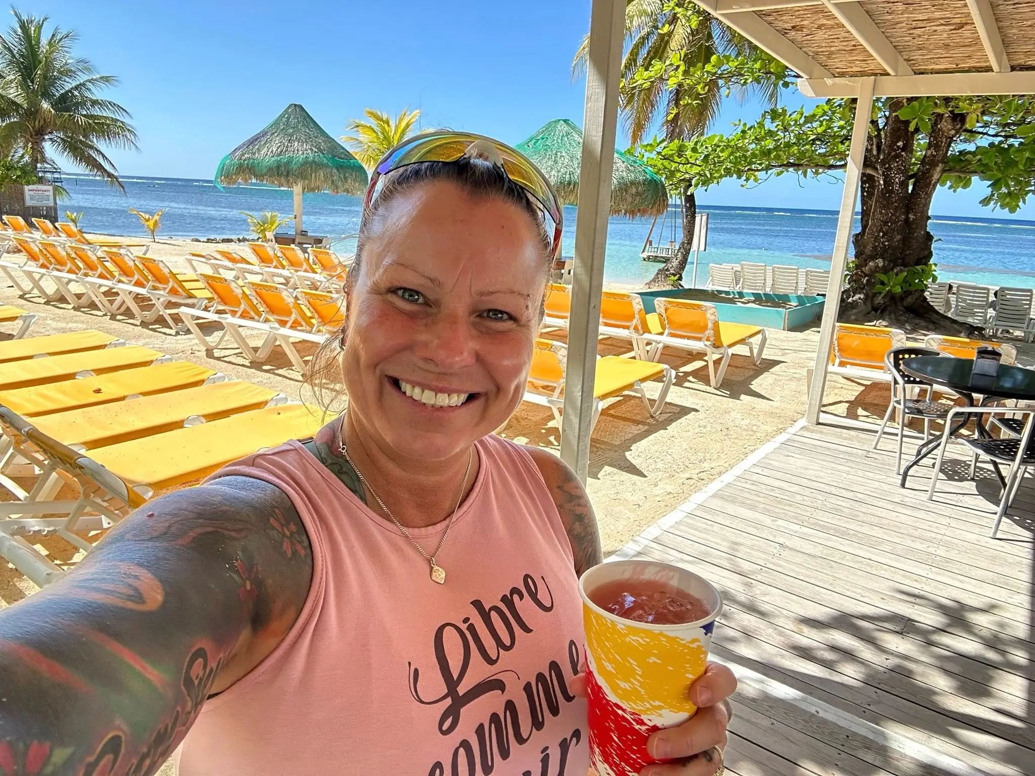 Guests enjoying clear Caribbean water and white sand with a Sol y Mar Roatan day pass