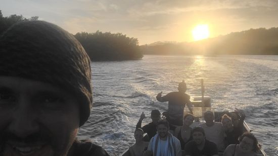 Excursions en Français avec un Guide Québécois à Roatan 14 Patrice Roatan Québécois un Selfy avec un bateau plein de voyageurs très heureux au coucher du Soleil