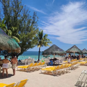 Guests enjoying clear Caribbean water and white sand with a Sol y Mar Roatan day pass